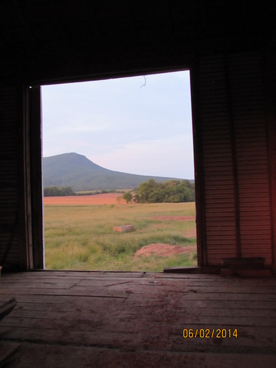 Mountain view of Massanutten Peak looking through large barn doors during wedding barn renovation.