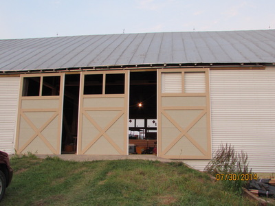 Installing barn doors during barn renovation for Cross Keys Barn wedding venue in Virginia.