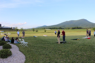 Wedding guests playing yard games at barn wedding venue.